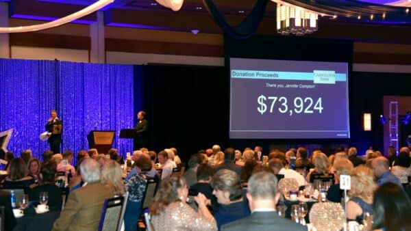 the fundraising gala and a big screen showing 73,924 dollars have been raised in donation proceeds