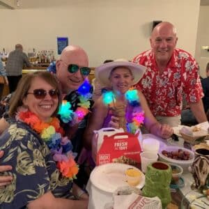 a group or participants sitting around a table at the trivia night dressed in bright clothing