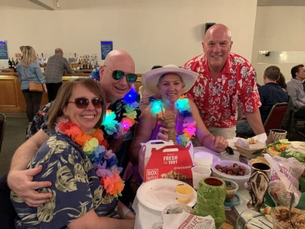 a group or participants sitting around a table at the trivia night dressed in bright clothing
