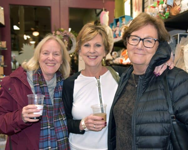Three women smiling and enjoying some drinks at a fundraising event
