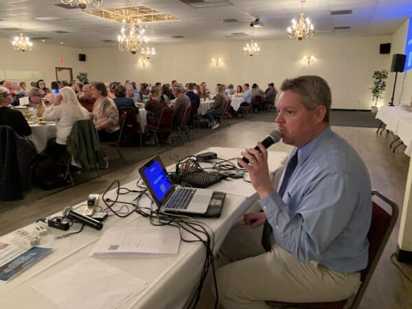 the MC of the trivia night holding a microphone asking questions